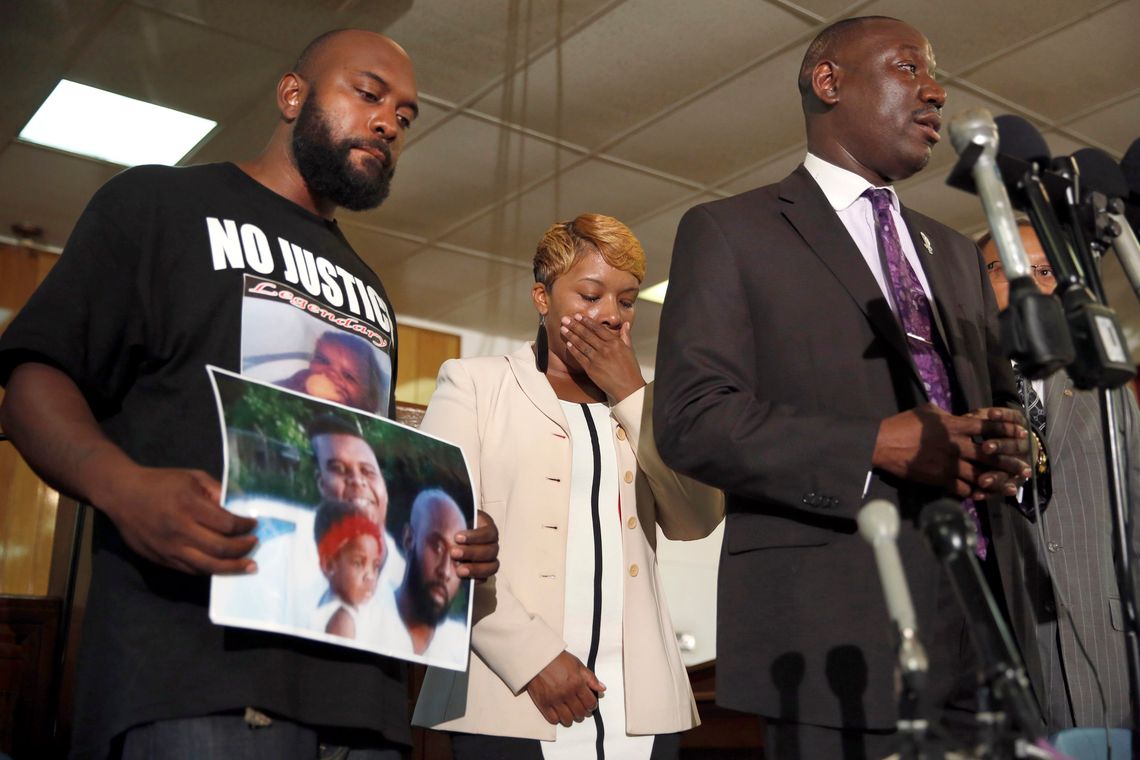 Lesley McSpadden, center, and Michael Brown Sr., left, the parents of Michael Brown, listen as attorney Benjamin Crump speaks during a news conference Monday, Aug. 11, 2014, in Jennings, Mo. Michael Brown, 18, was shot and killed in a confrontation with police in the St. Louis suburb of Ferguson, Mo, on Saturday, Aug. 9, 2014. (AP Photo/Jeff Roberson)