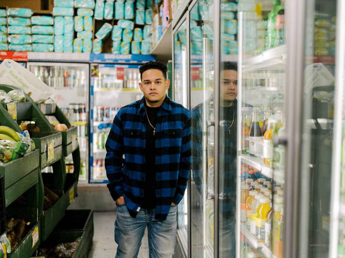 Jason Vargas, who hopes to join the New York Police Department, at his father’s deli in the Bronx in August 2021.