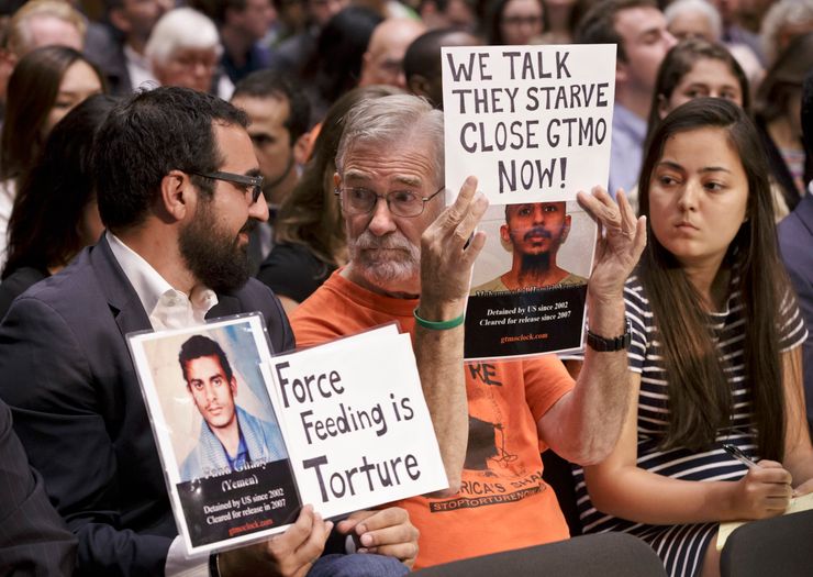 Audience members held signs and photos of Guantanamo detainees at a hearing by the Senate Judiciary Subcommittee on Constitution, Civil Rights & Human Rights, in Washington, during a hunger strike at the prison, on July 24, 2013.