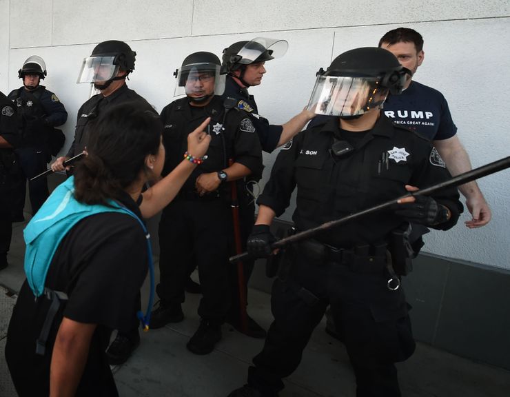 Police stand near a Trump supporter, right, as protesters gathered outside the convention center where Republican presidential candidate Donald Trump held an election rally in San Jose, California, June 2. 