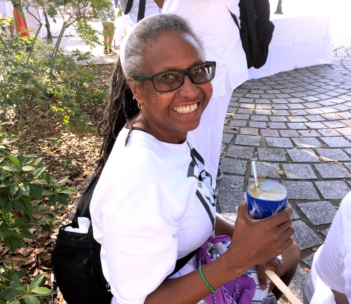 Portia Pollock, a 60-year-old Black woman with short gray hair, smiles at the camera while sitting in a park. 