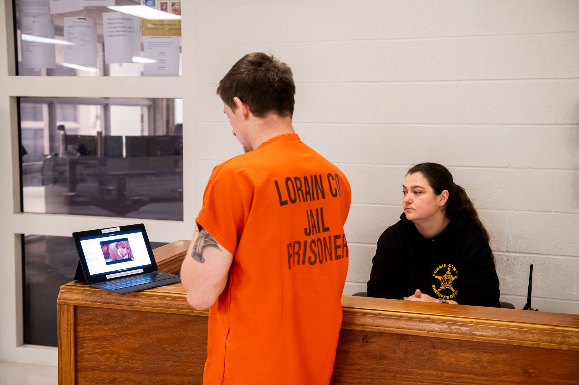 A person leaving Lorain County Jail watches a video about drug treatment services as part of the jail’s reentry program. 