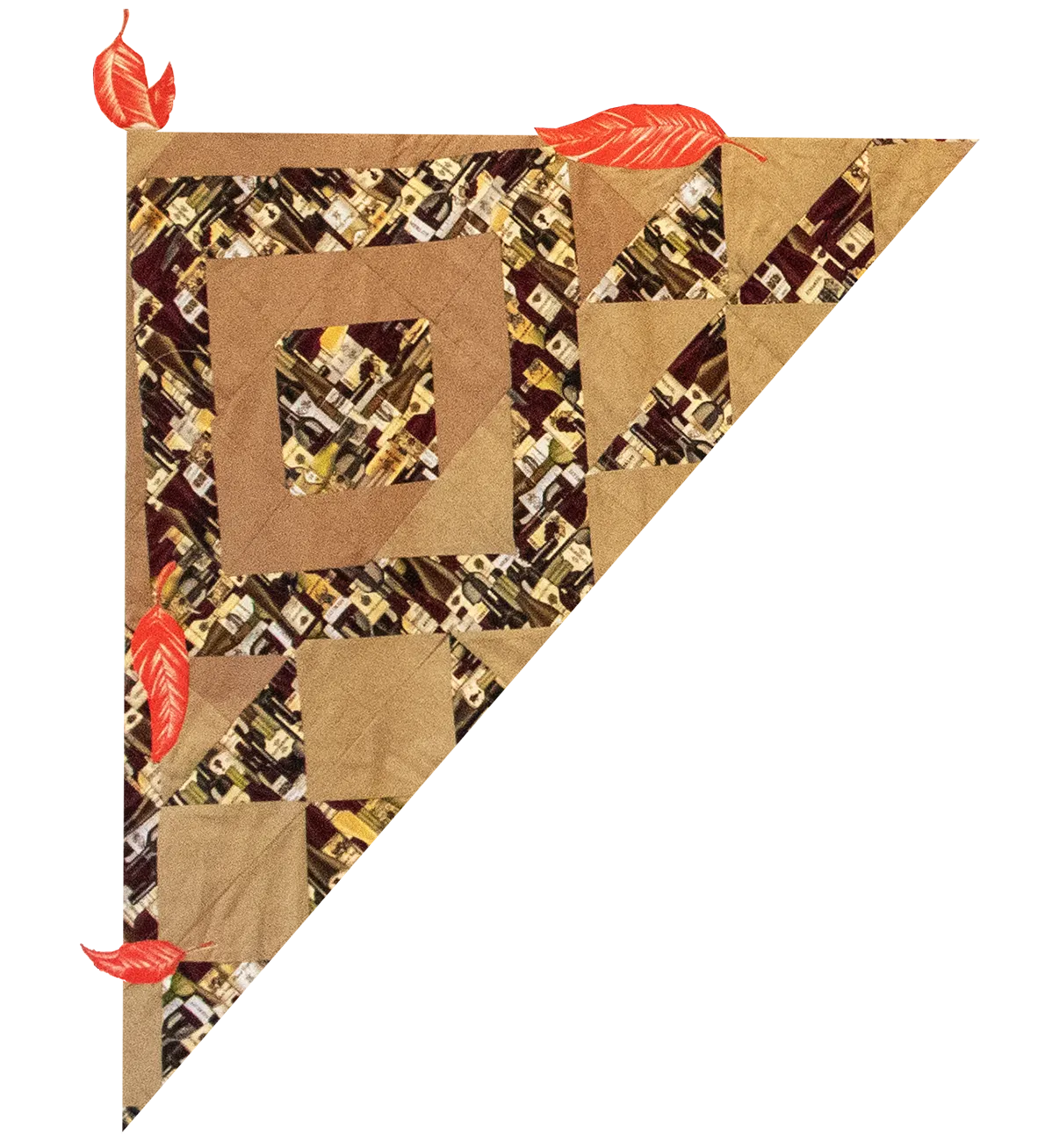  photo of a triangle-shaped piece of a quilt has square and triangle patterns within it made from fabric printed with liquor bottles. The colors in the quilt are in shades of brown and yellow, and some painted red leaves are at the edges and within the quilt triangle.