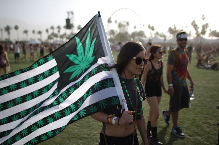 A woman carries  a flag bearing marijuana symbols at the Coachella Valley Music & Arts Festival in Indio, Calif., in April 2014.