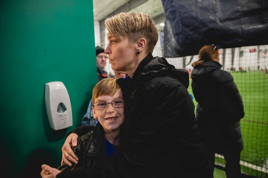 Jules hugs Julius at a soccer field.