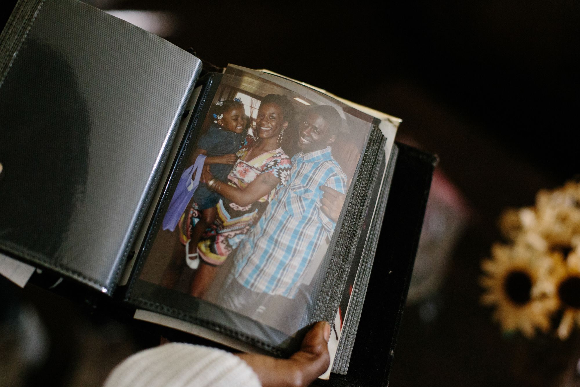 Chaney looks at a sparse photo album from her childhood on Oct. 8, 2020, where the page is open to an image of her holding her firstborn daughter, Amijah. 