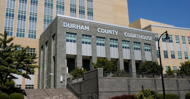 A gray building with a sign that reads: "Durham County Courthouse."  