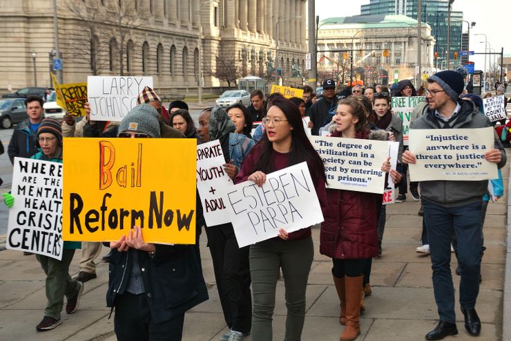 A group of more than 30 protestors walk through Cleveland’s downtown, holding posters advocating for bail reform and better conditions at the county jail. 