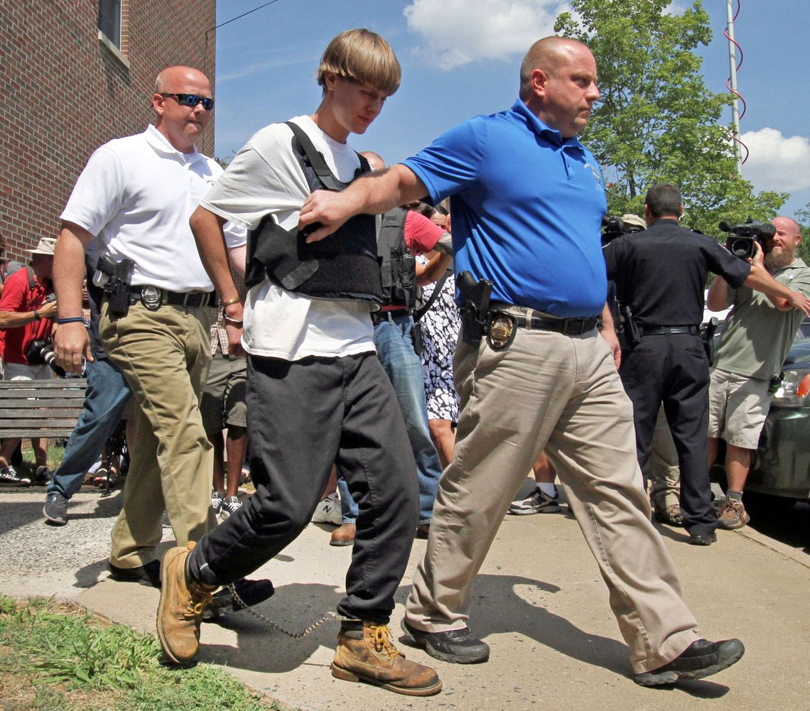 Dylann Storm Roof, center, is escorted from the Shelby Police Department in Shelby, N.C.