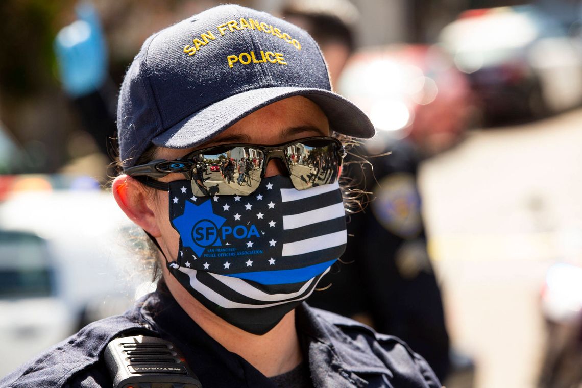 Some San Francisco police officers wore "thin blue line" flag face coverings at a housing protest in May. 