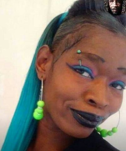 In a photo from her Facebook page, Tasha Grant, a Black woman, has teal hair and wears hoop earrings. 