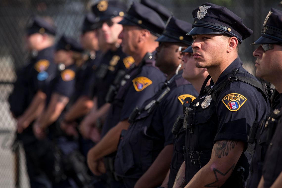 A group of Cleveland police officers in uniform stand in a line outdoors in 2016. 