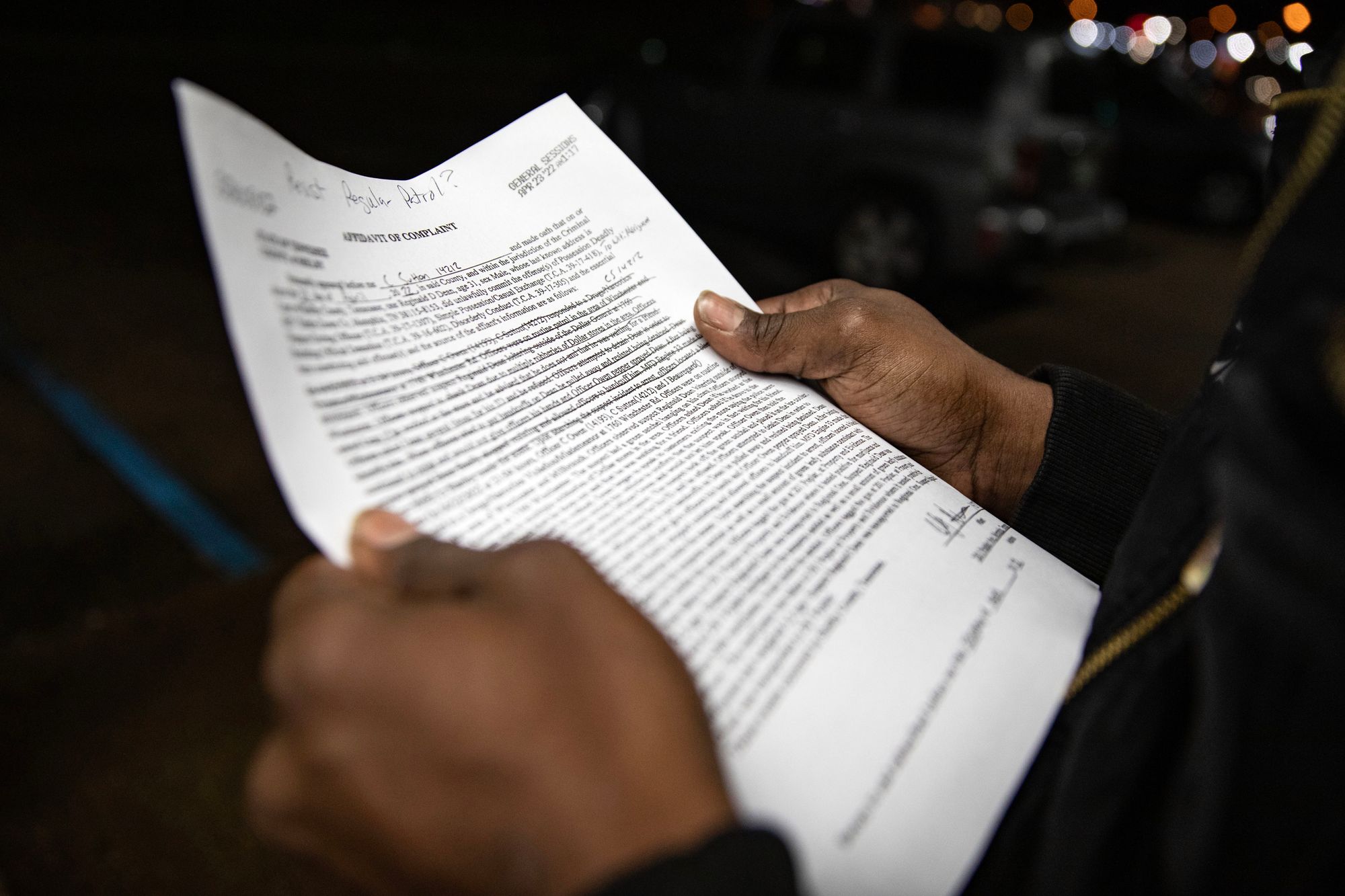 A photo shows Reginald Dean, a Black man, holding a piece of paper with text on it, outside a Dollar General store in Memphis, Tenn. 