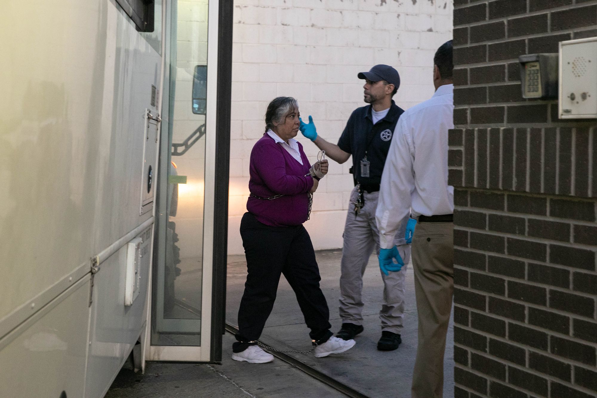 On an early September morning, migrants, with their ankles and wrists shackled, are brought by bus to the rear entrance of the federal courthouse in McAllen.
