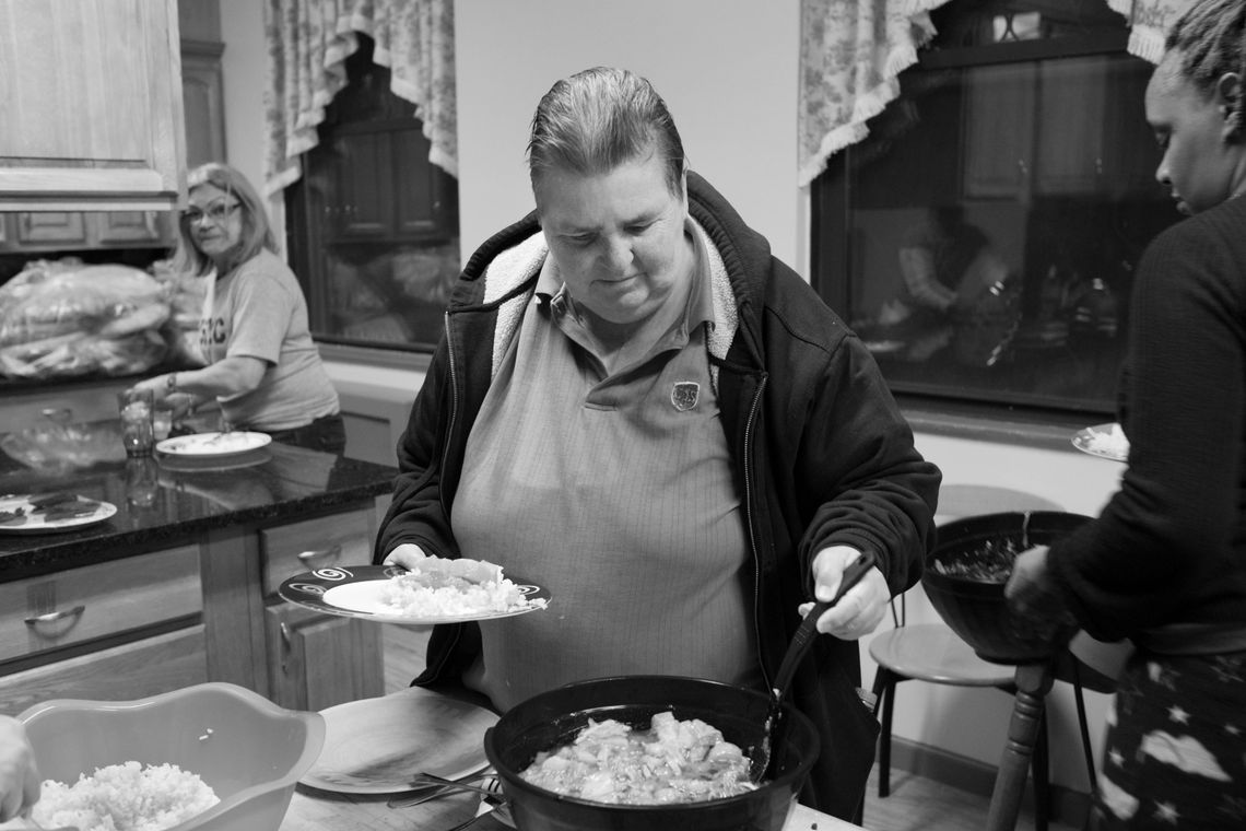 Carol, 65, attends a communal dinner at her transitional housing in Long Island City. 