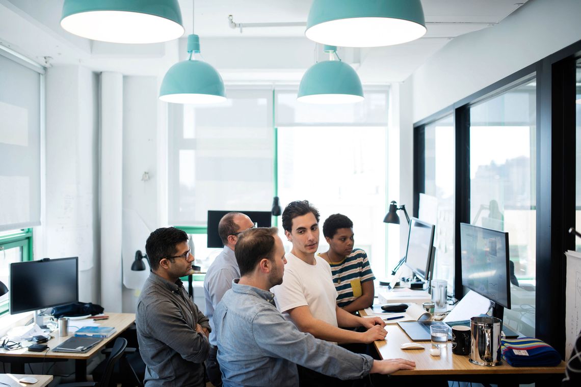 Michael Simon meets with his team in their office in Dumbo, Brooklyn. From left, customer development Sujeet Rao, co-founder Saul Shemesh (obscured), Simon, software engineer Freddie Andrade, and software engineer Kamille Johnson. 
