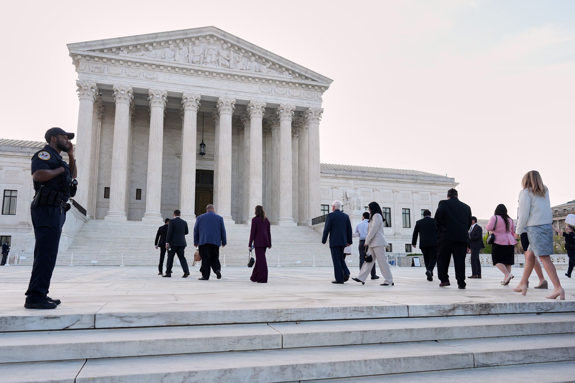 A photo shows people walking in front of the U.S. Supreme Court building. 