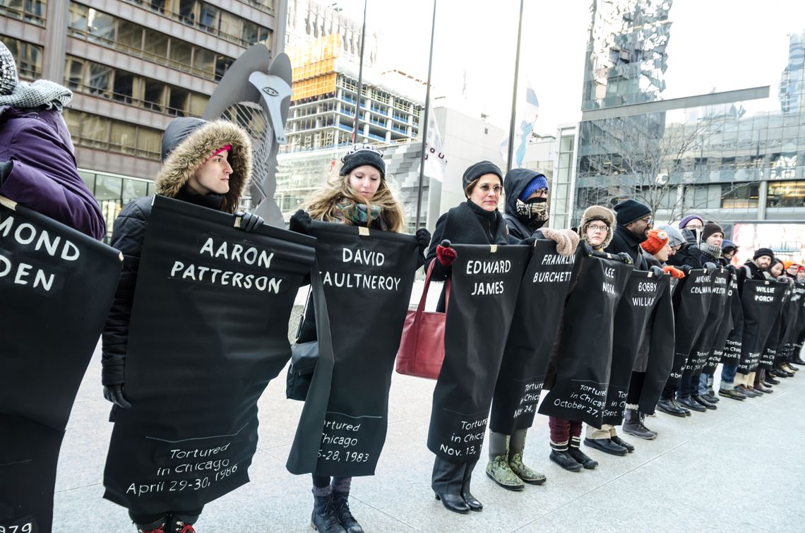 Protesters held banners with names of people tortured by police in Chicago. 
