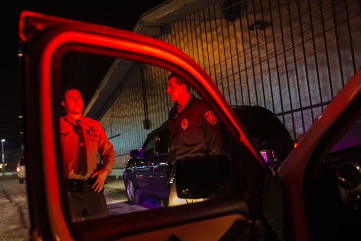 St. Louis County police Officers Thomas Keener, left, and Trevor Voss speak during a traffic stop in Jennings, Mo. in December. 