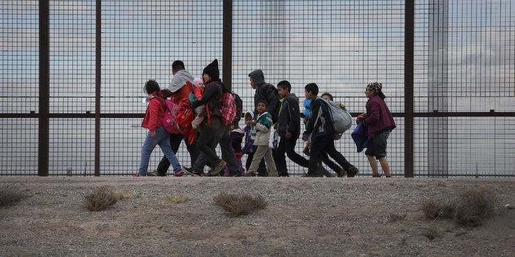 Central American immigrants walk along the border fence after crossing the Rio Grande from Mexico in February in El Paso, Texas. The migrants later turned themselves in to U.S. Border Patrol agents, seeking political asylum in the United States. 