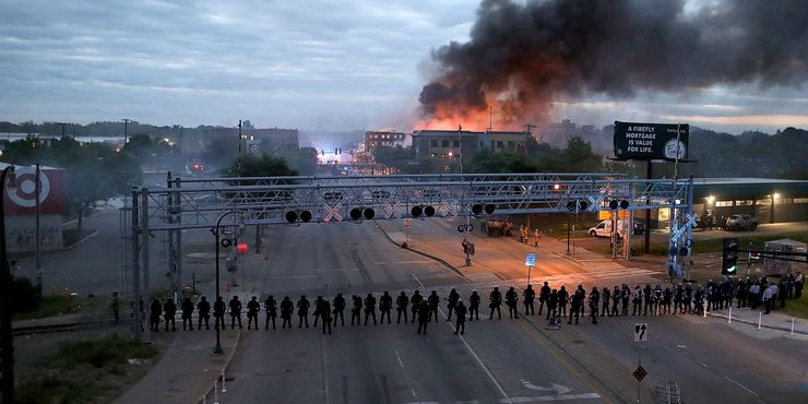 Law enforcement officers amassed along Lake Street in Minneapolis as fires burned during a night of unrest and protests over the death of George Floyd.  