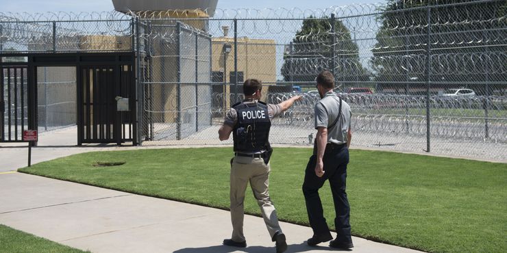 A police officer and a correctional officer patrol the entrance of the El Reno Federal Correctional Institution in El Reno, Oklahoma.  