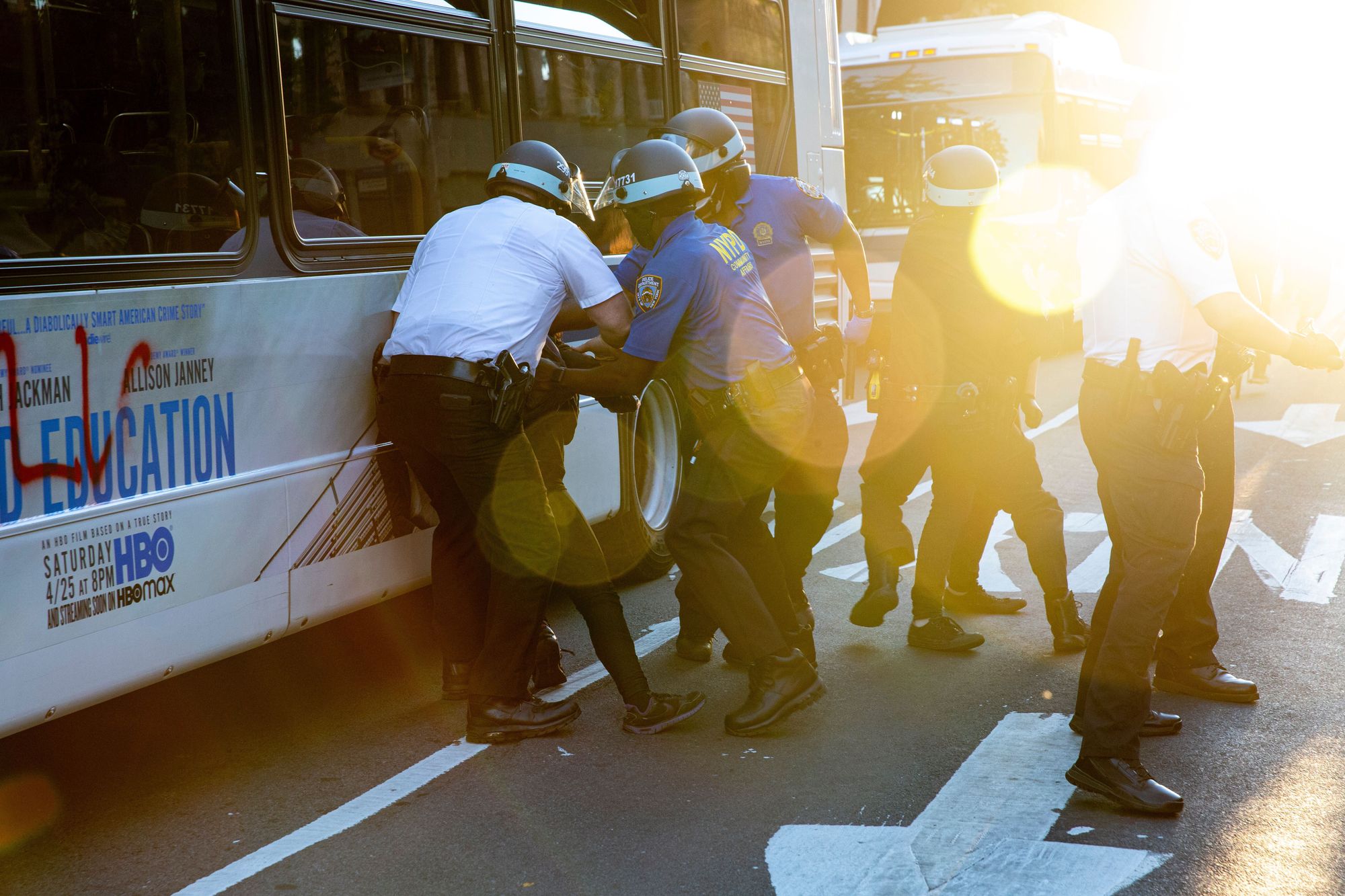 Police arrest two women for spray painting a local bus in downtown Brooklyn with the acronym FTP (“Fuck the Police”). They had started writing “No Poli…” when officers grabbed them, knocking them to the ground.