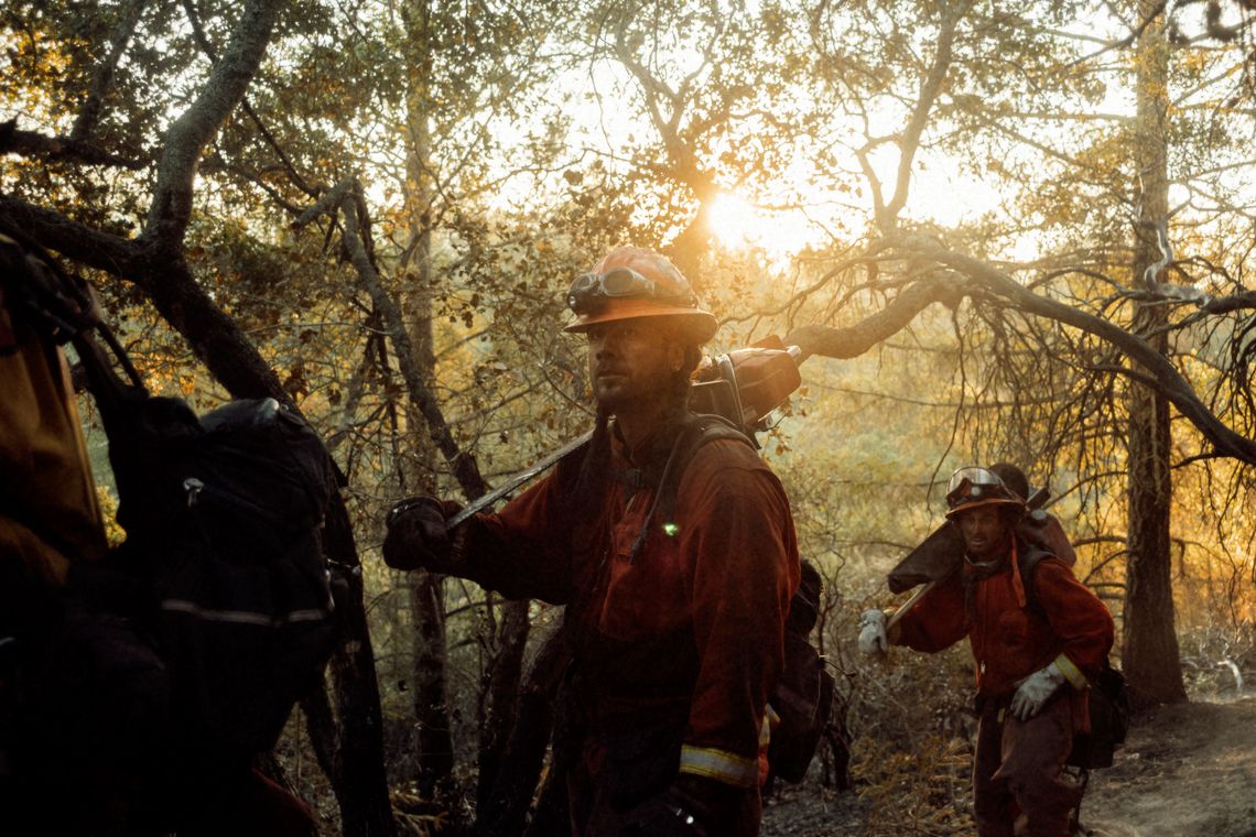 The Antelope fire crew marches into action in Sonoma County, Calif. Much of a crew's work is done by cutting lines into burning brush with power tools so that water lines can be brought in to douse the fire.