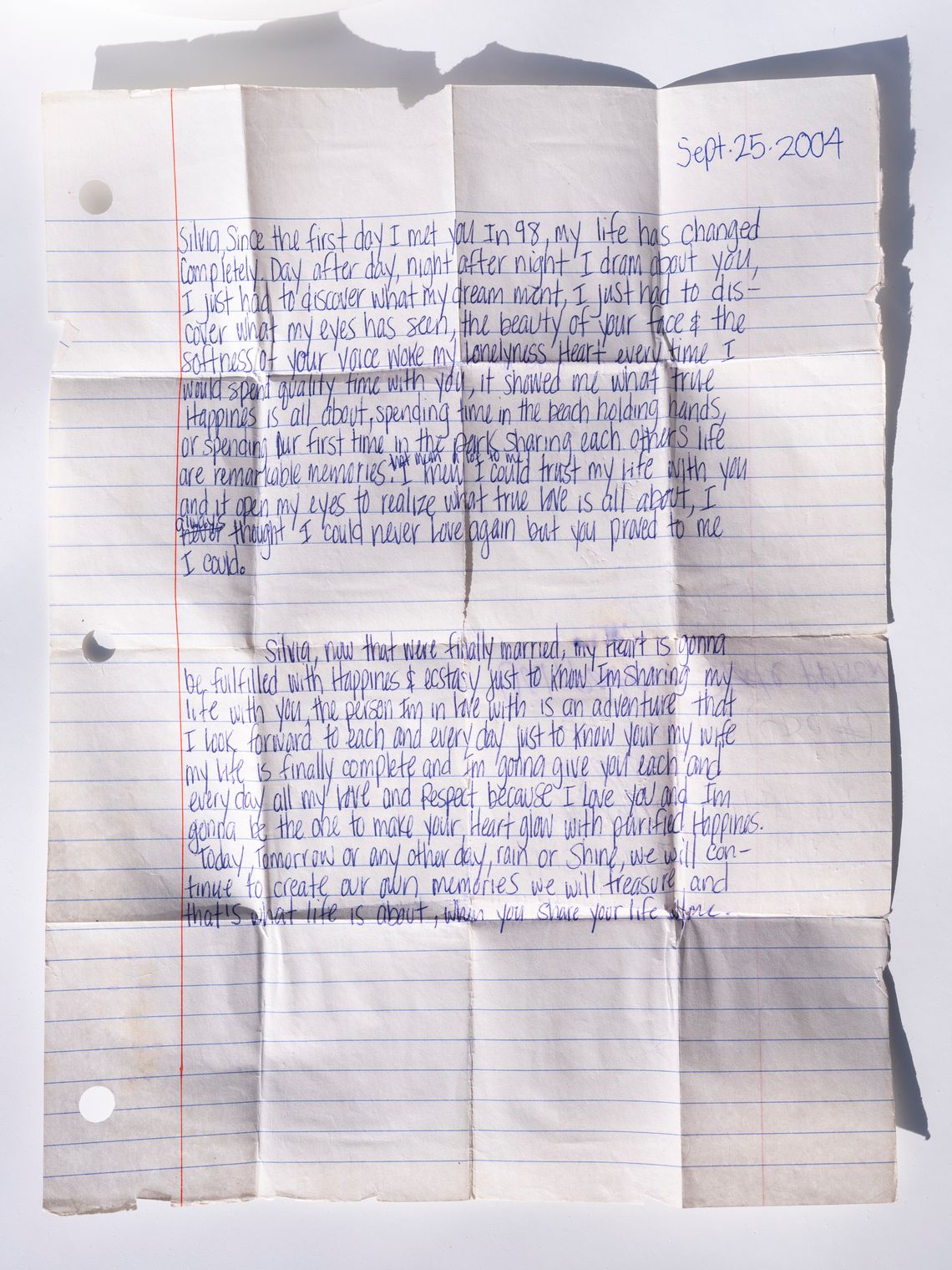 Handwritten vows on a piece of notebook paper read: "Silvia, since the first day I met you in 98, my life has changed completely. Day after day, night after night, I dr[e]am about you, I just had to discover what my dream meant, I just had to discover what my eyes has seen, the beauty of your face and the softness of your voice woke my lonel[i]ness heart every time I would spend quality time with you, it showed me what true happiness is about..."