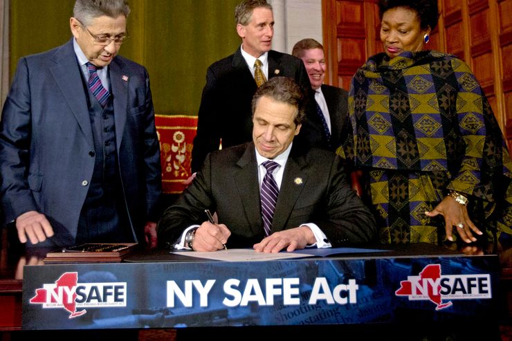 New York Gov. Andrew Cuomo signs the Secure Ammunition and Firearms Enforcement (SAFE) Act into law at the Capitol in Albany on Jan. 15, 2013. 