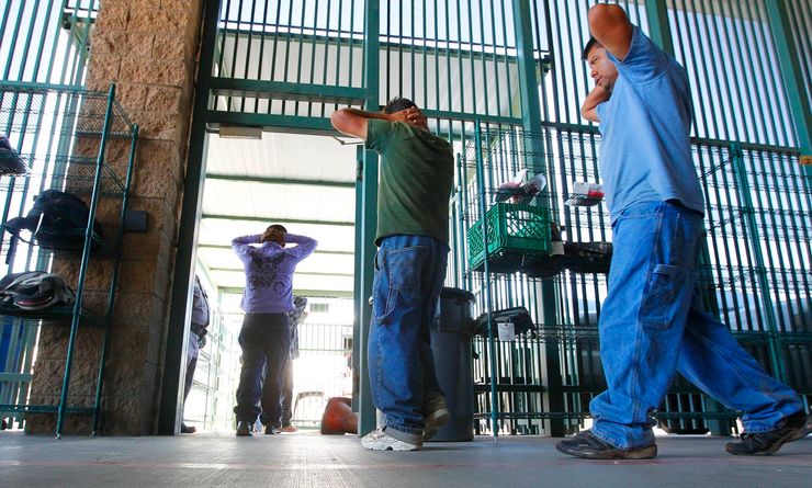 Suspected undocumented immigrants are transferred out of the holding area after being processed in Tucson, Ariz., in August 2012.