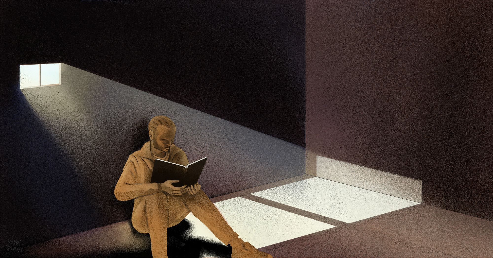 A prisoner sits inside a dark cell, reading a book. Light from a small window shines through the room. 