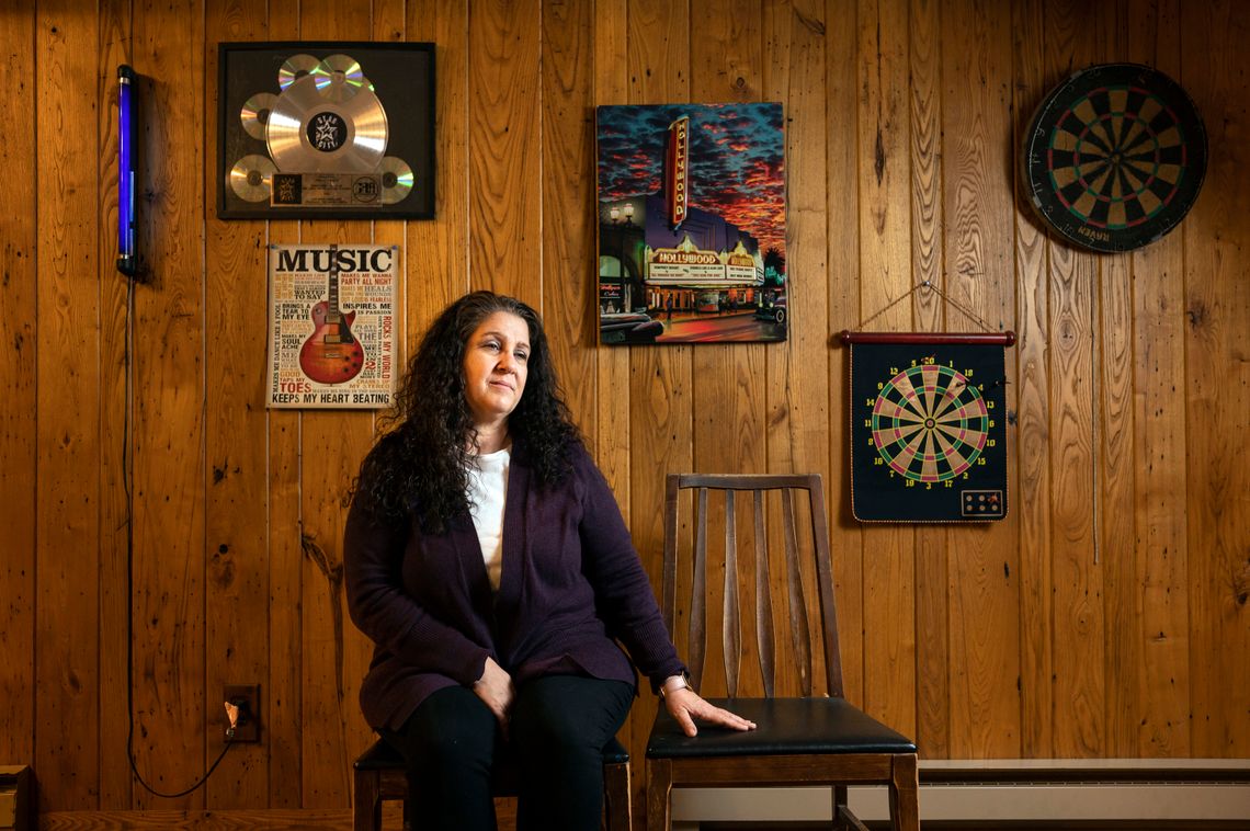 Jodi Calkins at her home in Elkins, West Virginia, in December. The decorations on the wall include framed artwork of the former record label of her son, who is at FCI Seagoville in Texas.
