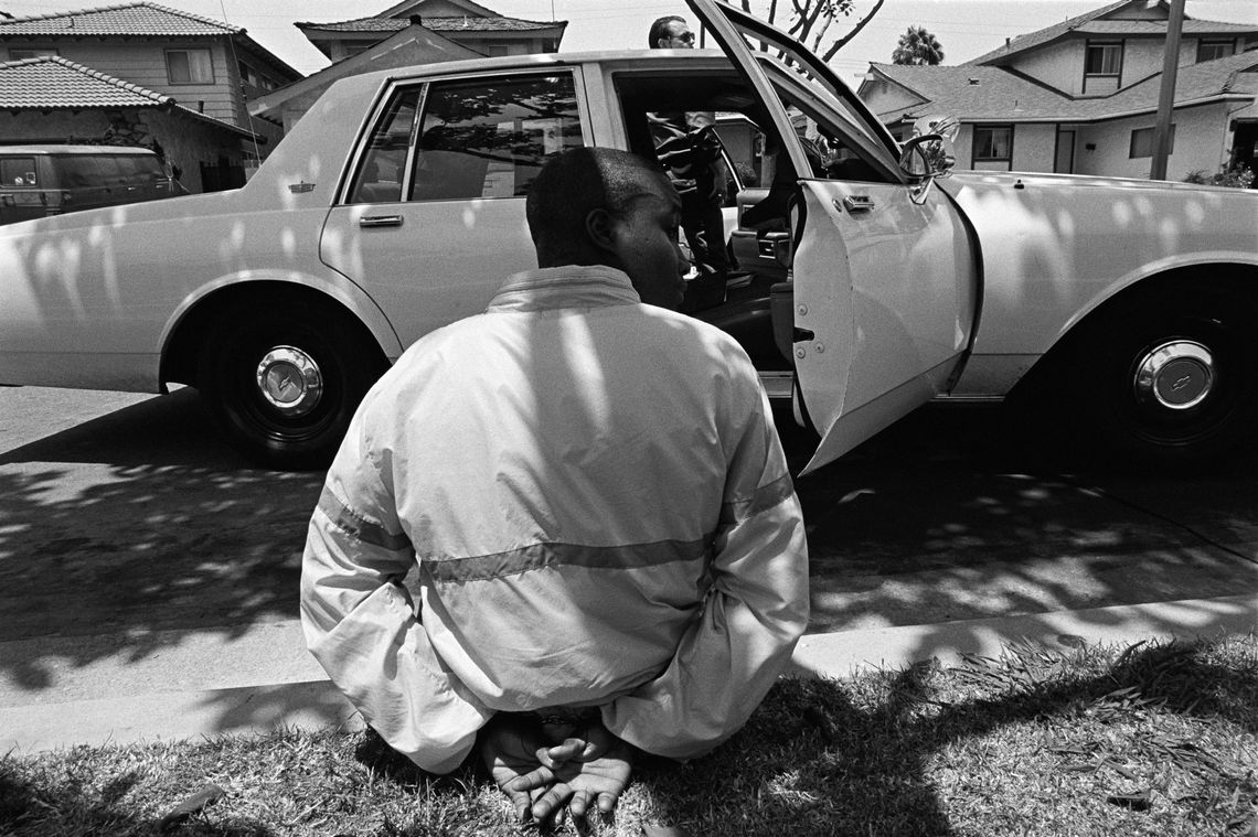 A gang task force holds an alleged truant. (Los Angeles, 1992)