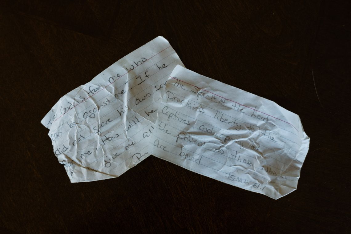 A photo shows two index cards on a black background. One reads: “If God is for me, who can be against me? If he did not spare his own son for me. How will he give me…” The other reads: “The spirit of the Lord proclaims liberty to the captives and opening of the prison to those who are bound.”