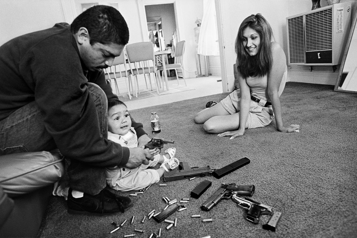 Chivo teaches his daughter how to hold a .32-caliber pistol in the Boyle Heights neighborhood of Los Angeles, Ca., in 1993. 
