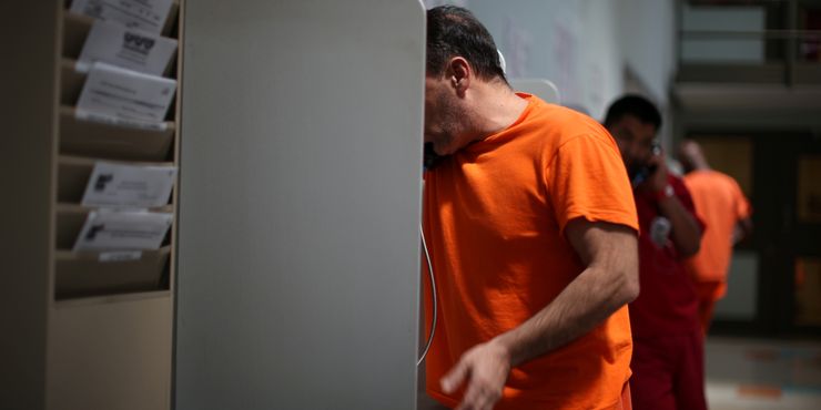 Detainees make phone calls at a federal immigration detention center in California that is run by the private GEO Group. 