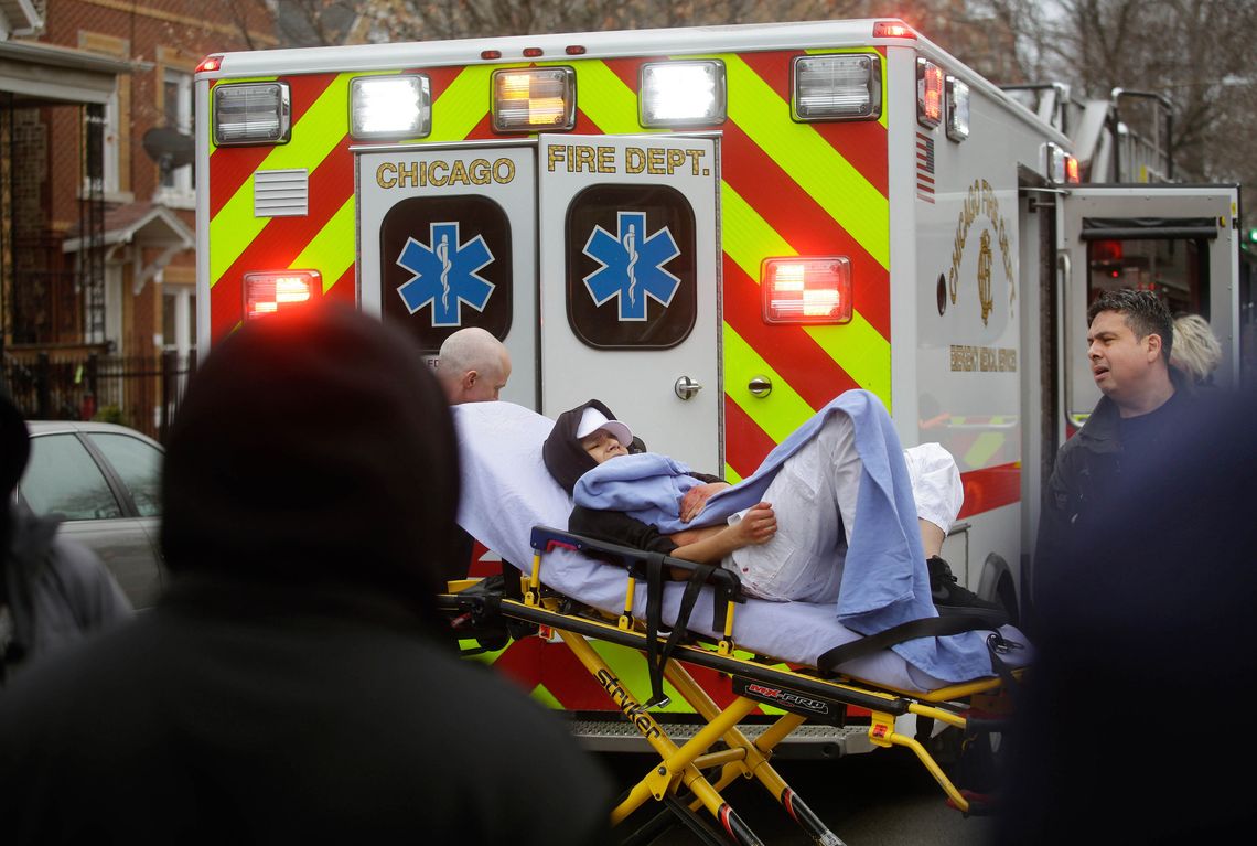 A Chicago Fire Department paramedic and firefighter take a man who was shot to a waiting ambulance near the Cook County Jail in Little Village. 