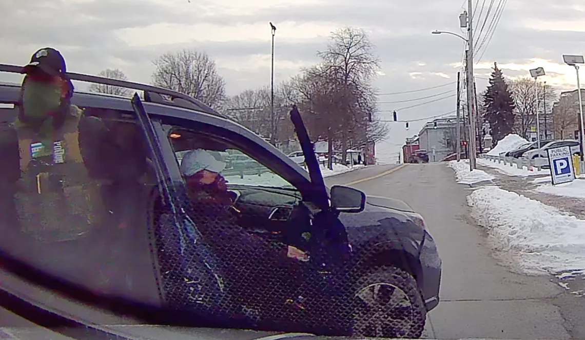 In a photo, two masked agents are exiting a dark colored SUV. The vehicle is stopped on a street, and sidewalks lined with snow are visible in front of it.