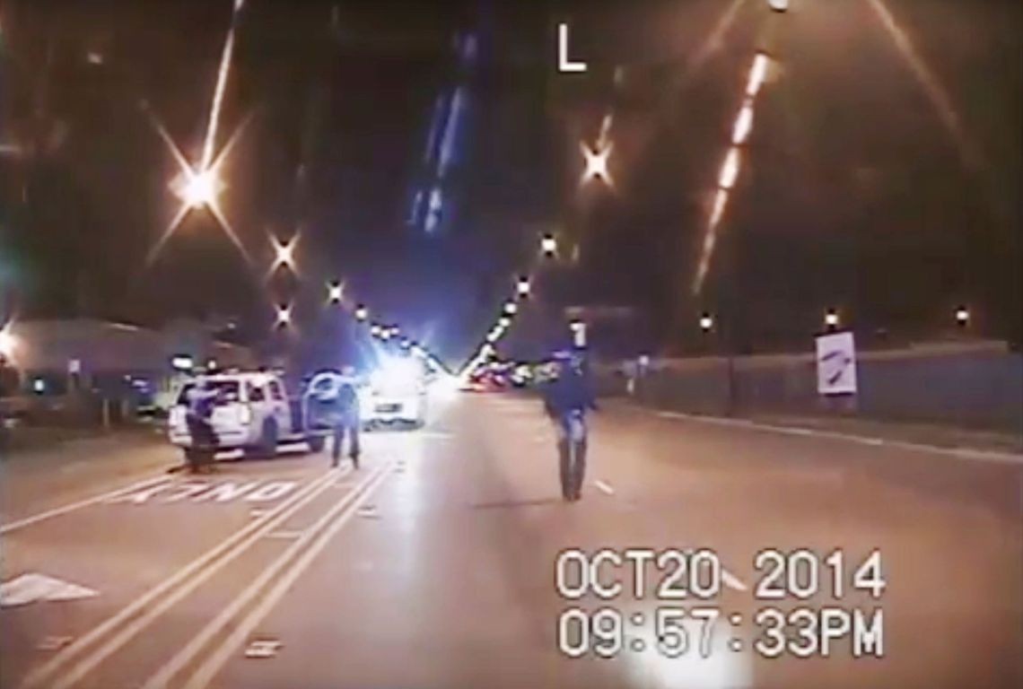 A still image from a dash-cam video of Laquan McDonald, right, walking down a Chicago street moments before being fatally shot by Chicago Police officer Jason Van Dyke in October 2014.