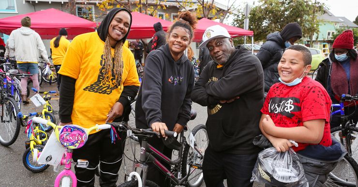 Volunteer Ayanna Elliott-Green, left, All of Us or None cofounder Dorsey Nunn, second from right, and two bike recipients at the organization’s 23rd Annual Community Giveback in 2022.