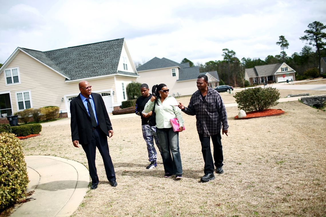 From left, Leon Brown, David Brown, Geraldine Brown and Henry McCollum explore a rental home they were able to secure with a bank loan. 