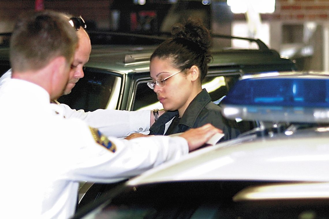 Shonda Walter, right, is placed into a police car in Lock Haven, Pa., after being found guilty of first degree murder in April 2005.