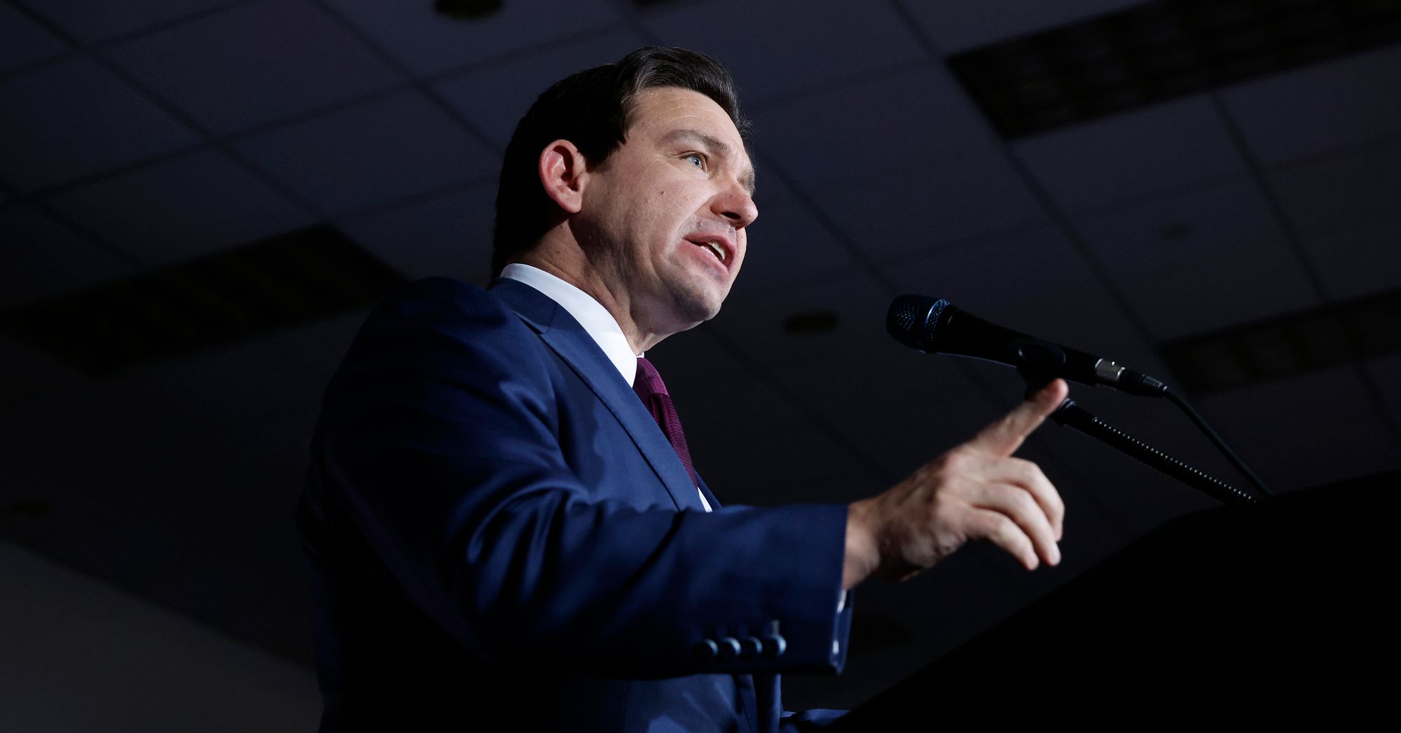 Florida Gov. Ron DeSantis, a White man, points a finger while giving a speech.  