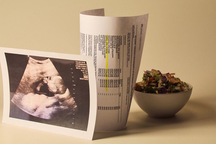 Three items are arranged on a white surface: a salad in a white bowl, a copy of a sonogram, and a printout of a false positive drug test result.