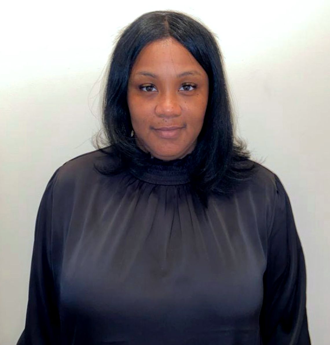 Deshanna Graham, a Black woman with long hair wearing a black shirt. 