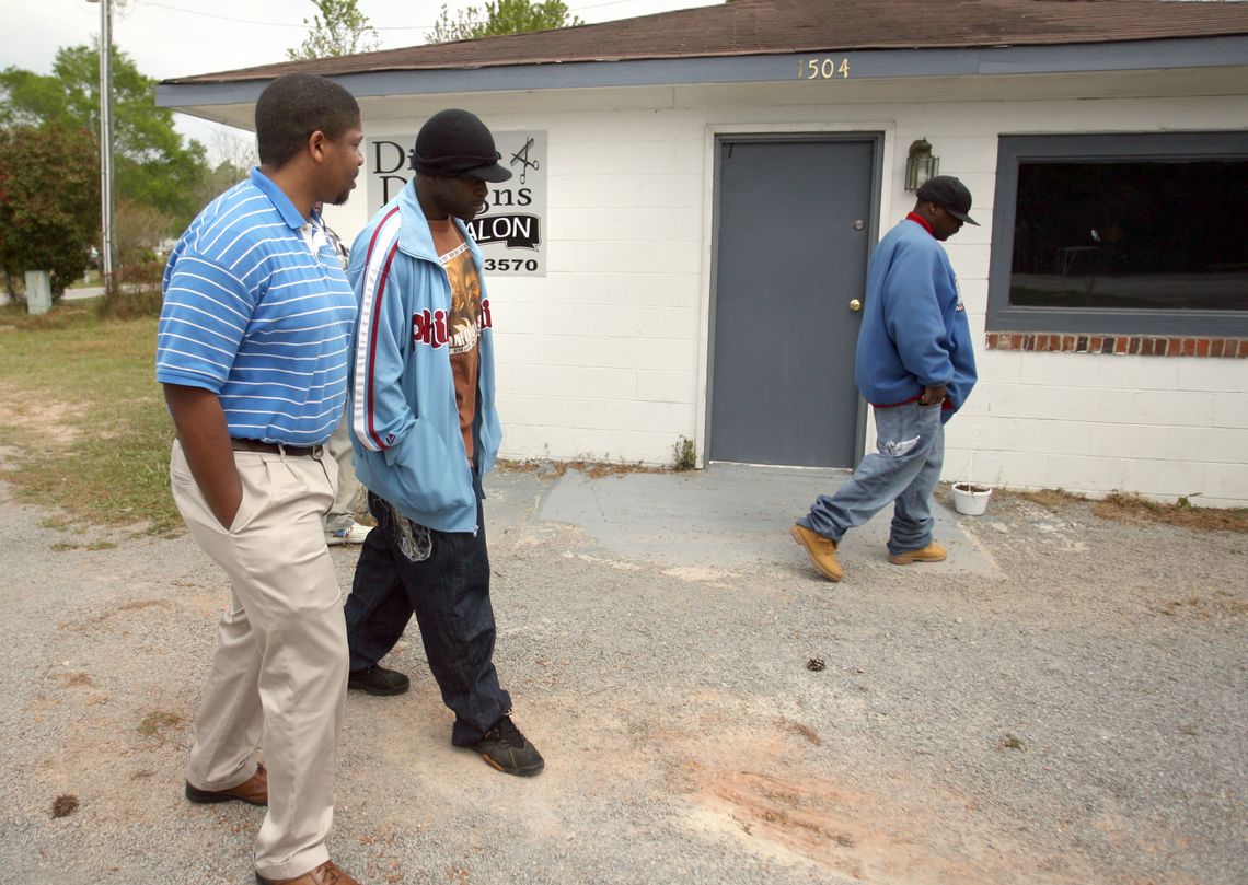 Issac with family at the scene of Bunch's murder. The building now houses a hair salon.