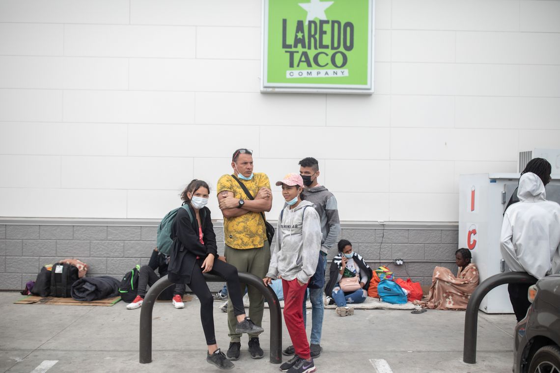 From left, siblings Alejandra, Nellysmar and Derek; and their father, Alberto Zaragoza, in a yellow shirt; waited at a gas station in Del Rio, Texas, for a bus to San Antonio. Dozens of people spend each night here, since there is no overnight shelter for migrants in Del Rio.