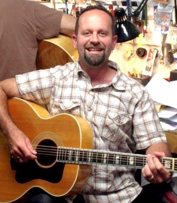 A White man in a brown and white plaid shirt. 