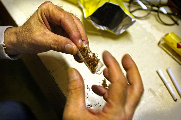 An inmate at Monroe Corrections Complex in Washington rolls a cigarette in May 2004.  